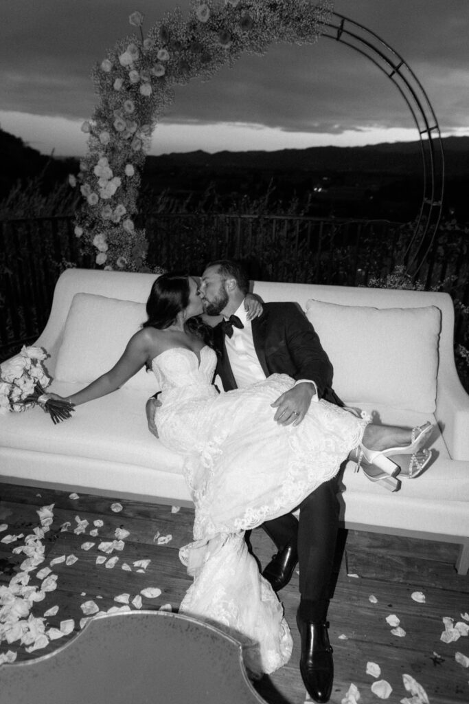 couple kissing during wedding day on lounge