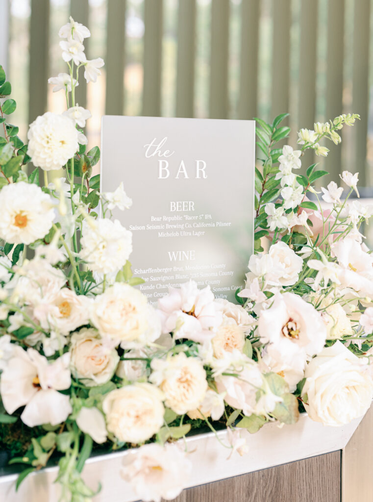 bar sign with nest of wedding flowers 