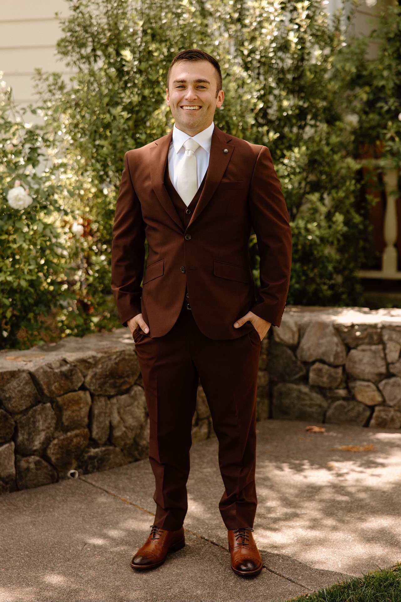 Groom in burgundy suit at his Harrow Cellars wedding