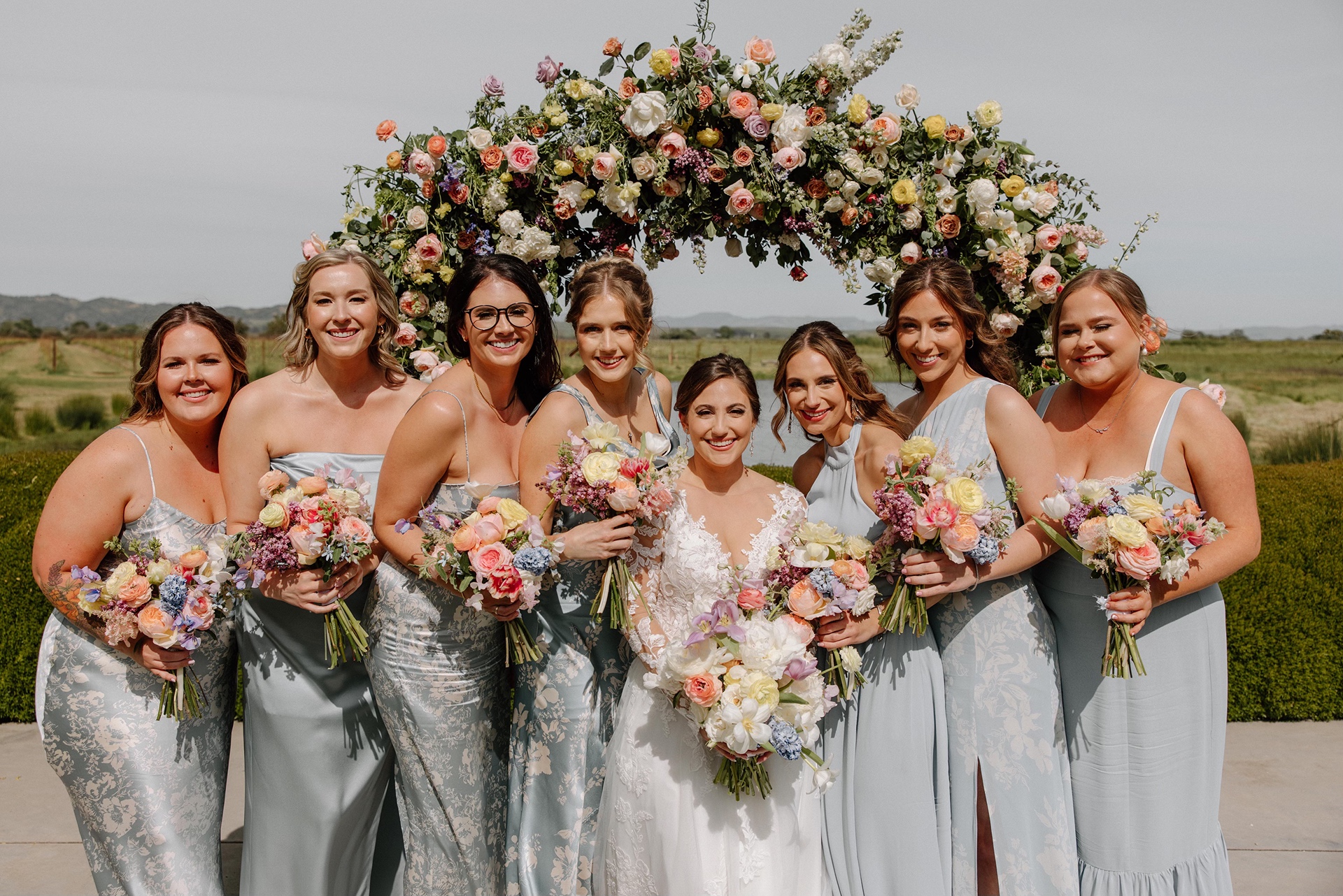 Bride with bridesmaids in blue dresses at Harrow Cellars wedding